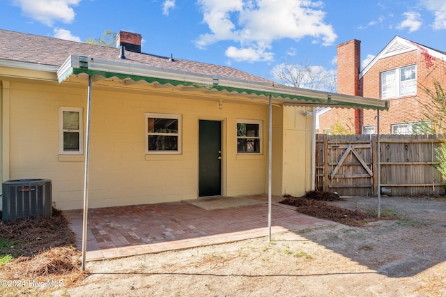 back of property with a patio and central AC