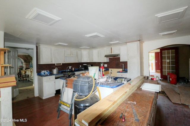 kitchen with decorative backsplash, dark hardwood / wood-style flooring, and white cabinetry