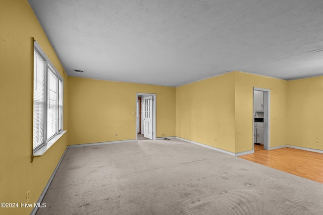 carpeted empty room with a textured ceiling