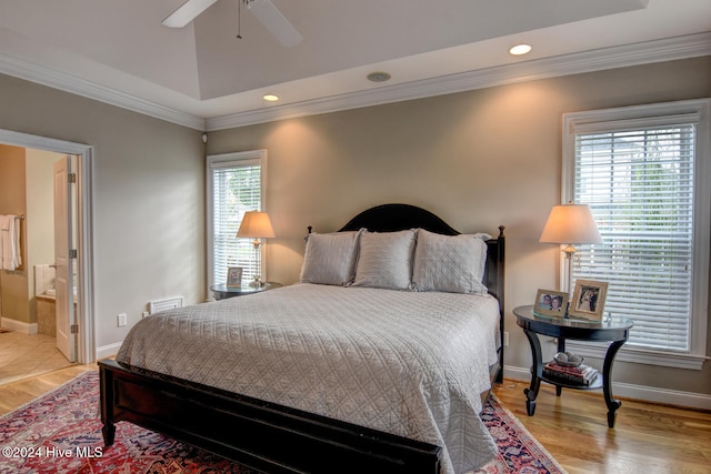 bedroom featuring connected bathroom, multiple windows, ceiling fan, and light hardwood / wood-style flooring