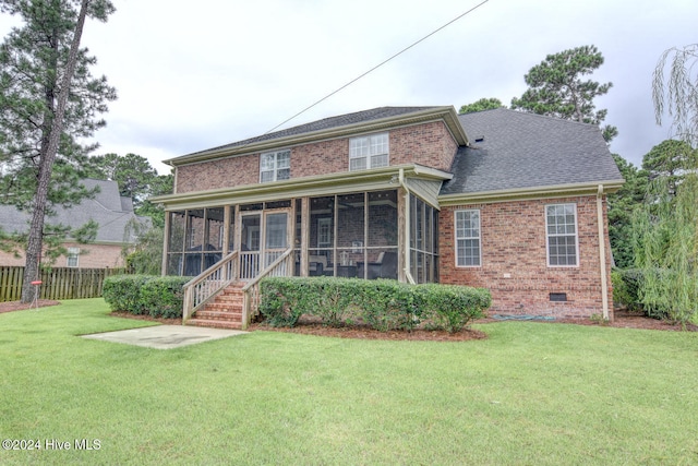 rear view of property featuring a sunroom and a yard