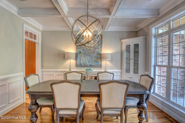 dining space with a chandelier, a healthy amount of sunlight, coffered ceiling, and light hardwood / wood-style floors