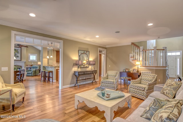 living room with ornamental molding and light wood-type flooring