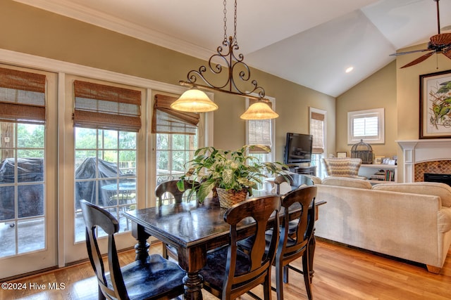 dining space featuring a healthy amount of sunlight, light hardwood / wood-style floors, and vaulted ceiling