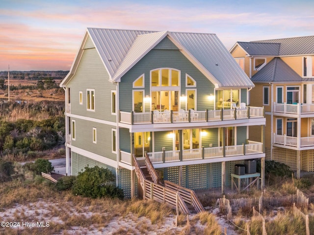 back house at dusk with a balcony