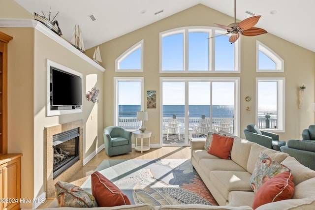 living room with ceiling fan, high vaulted ceiling, and light hardwood / wood-style flooring