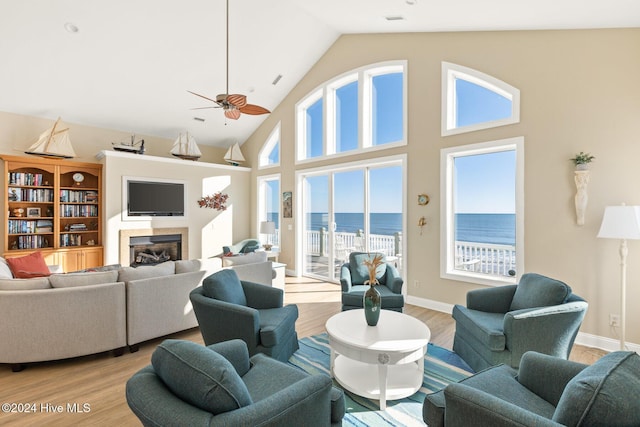 living room with ceiling fan, high vaulted ceiling, and light hardwood / wood-style floors