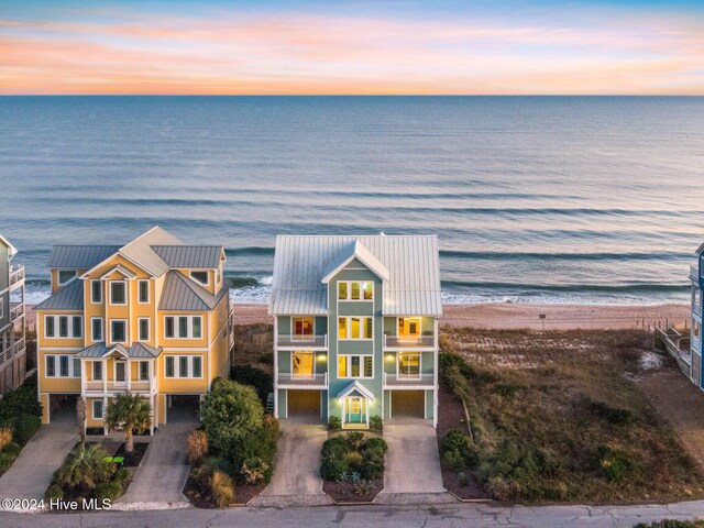 back house at dusk featuring a balcony