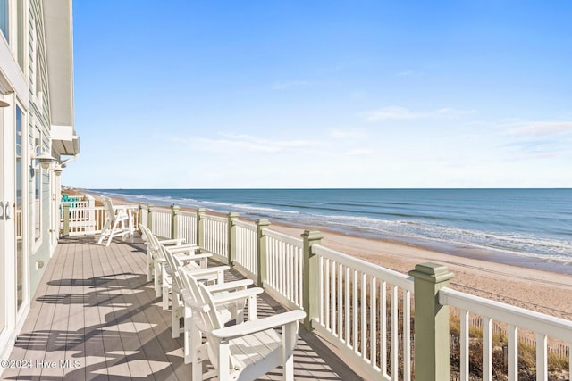 balcony featuring a view of the beach and a water view