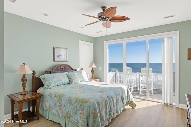 bedroom with a water view, access to exterior, ceiling fan, and light hardwood / wood-style flooring