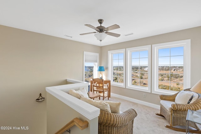 living area with light colored carpet and ceiling fan