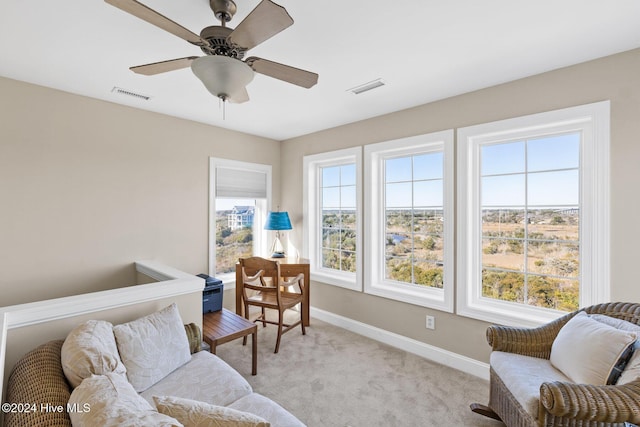 living area with light colored carpet and ceiling fan