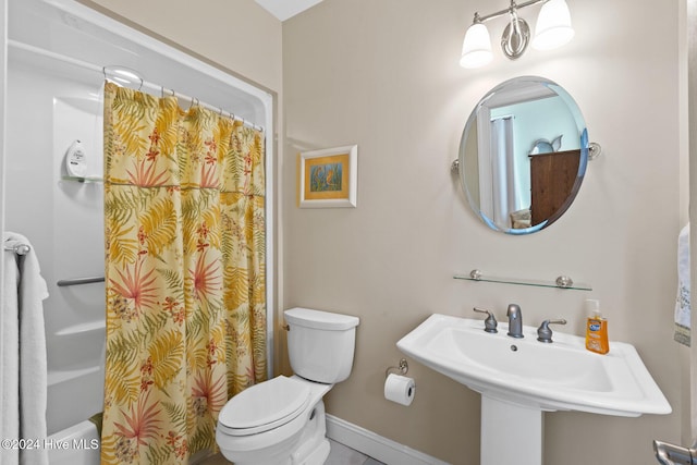 bathroom with sink, a shower with shower curtain, and toilet