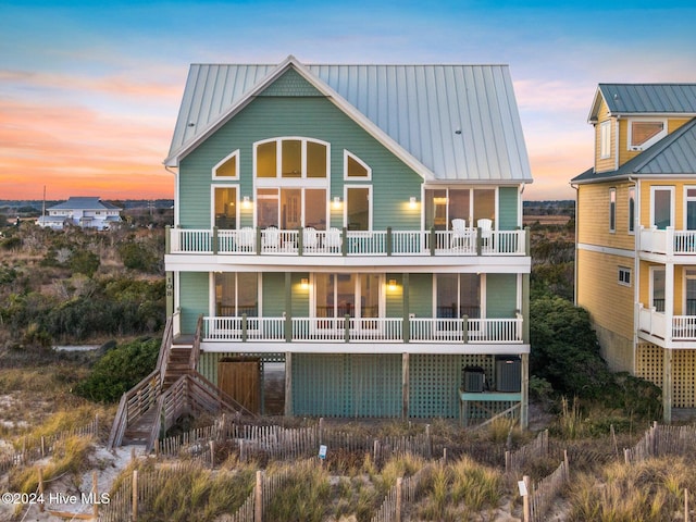 back house at dusk with a balcony