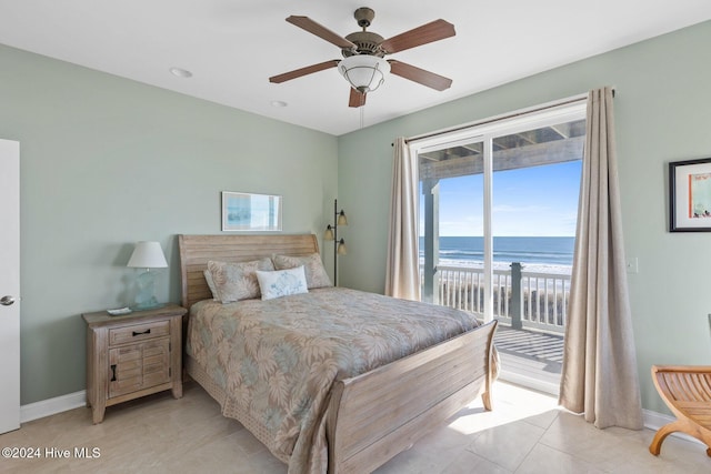 bedroom featuring light tile patterned flooring, a view of the beach, access to exterior, ceiling fan, and a water view