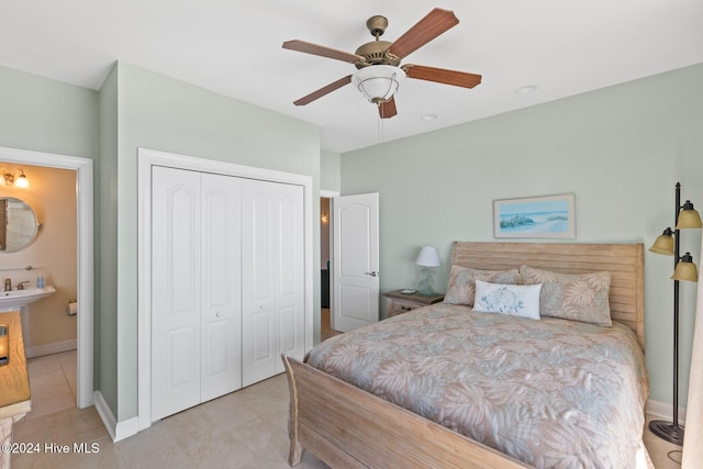 bedroom with sink, ensuite bath, a closet, and ceiling fan