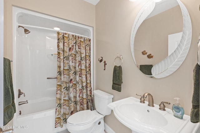 full bathroom featuring sink, shower / bath combination with curtain, and toilet