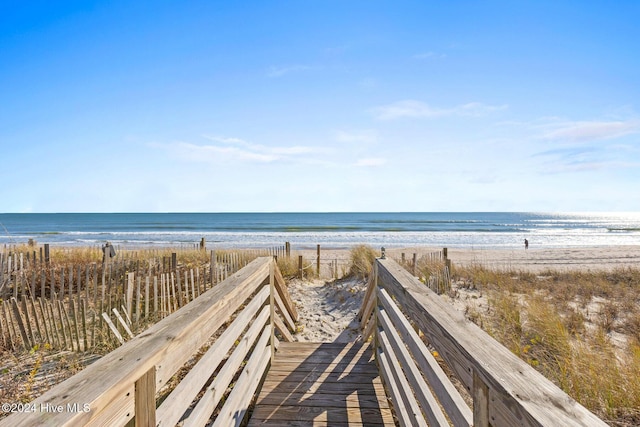 view of community with a beach view and a water view