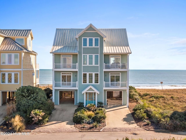 view of front of home featuring a carport, a water view, and a beach view