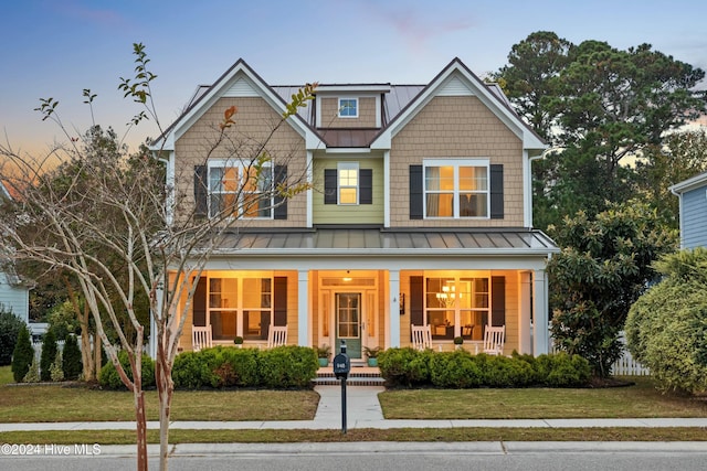 craftsman-style home featuring a porch and a yard