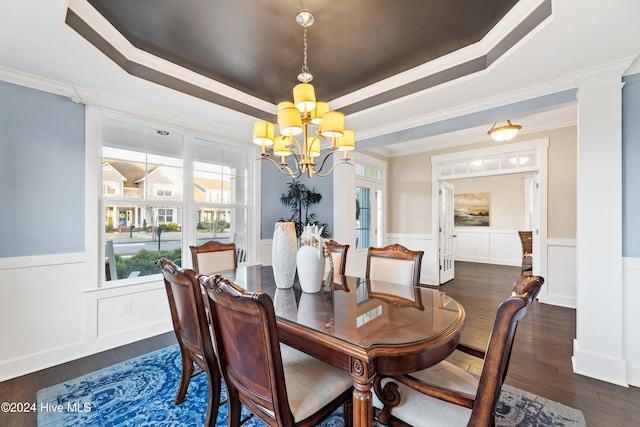 dining area featuring dark hardwood / wood-style floors, a raised ceiling, crown molding, and an inviting chandelier