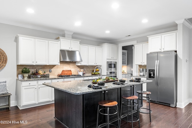 kitchen featuring dark hardwood / wood-style floors, white cabinetry, stainless steel appliances, and an island with sink