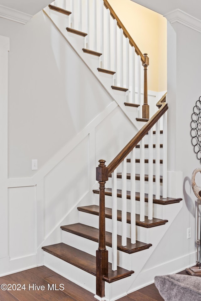 stairs featuring crown molding and hardwood / wood-style flooring