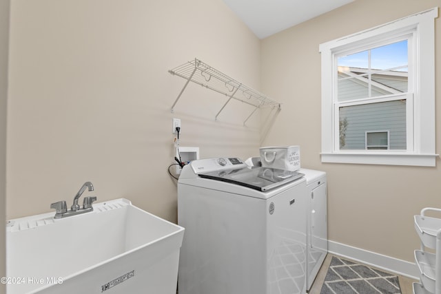 clothes washing area featuring sink and washing machine and clothes dryer