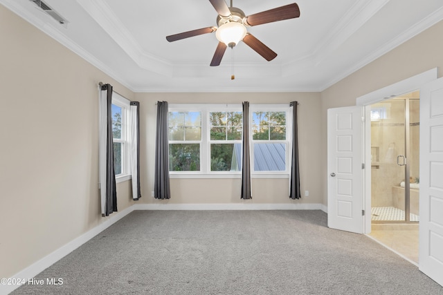 interior space featuring a raised ceiling, connected bathroom, ceiling fan, and carpet