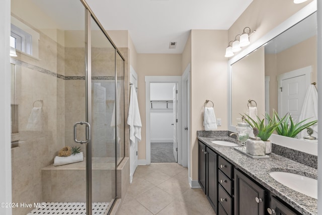 bathroom featuring tile patterned flooring, vanity, and an enclosed shower