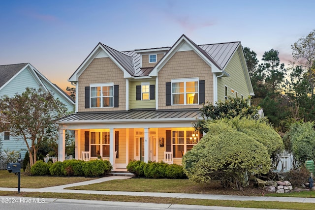 view of front of house with a lawn and a porch