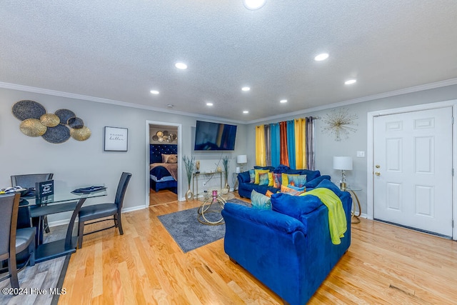 living room with crown molding, light hardwood / wood-style flooring, and a textured ceiling