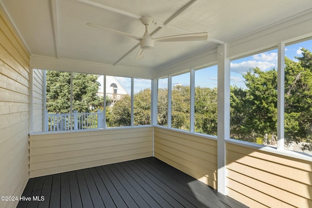 unfurnished sunroom with ceiling fan