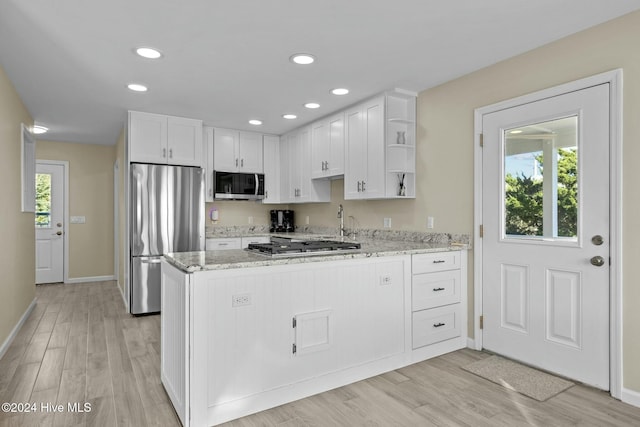 kitchen featuring white cabinets, stainless steel appliances, and a healthy amount of sunlight