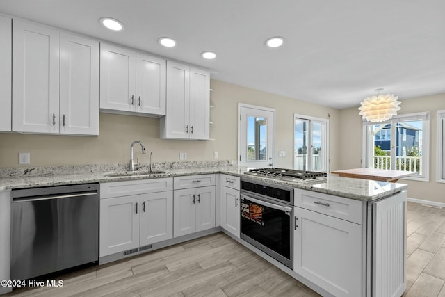 kitchen featuring sink, white cabinets, stainless steel appliances, and light wood-type flooring