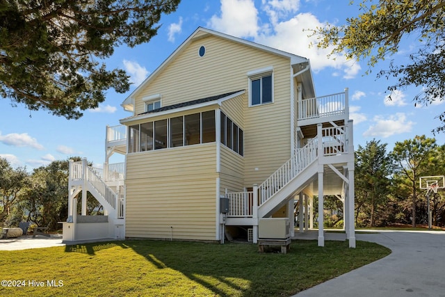 rear view of property with a yard and a sunroom