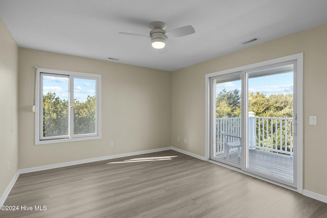 empty room with ceiling fan, light hardwood / wood-style flooring, and a healthy amount of sunlight