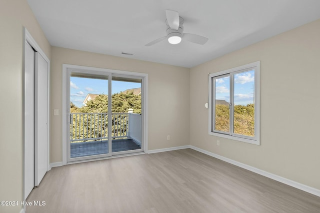 spare room with plenty of natural light, ceiling fan, and light wood-type flooring