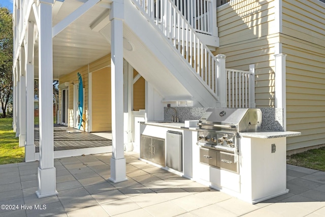 view of patio with an outdoor kitchen, area for grilling, and sink