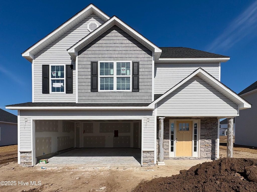 craftsman inspired home featuring an attached garage and stone siding