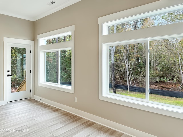 interior space with crown molding and light wood-type flooring