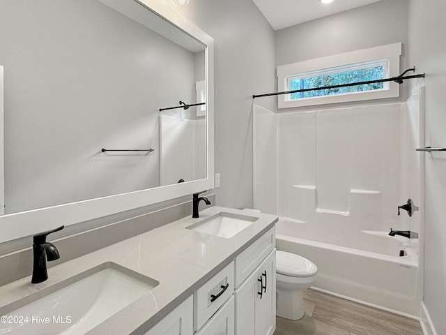 full bathroom featuring hardwood / wood-style floors, vanity, bathing tub / shower combination, and toilet