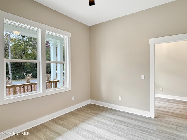 empty room with ceiling fan and light hardwood / wood-style flooring