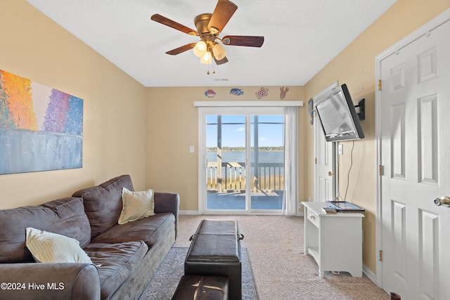 living room with ceiling fan, light colored carpet, and a textured ceiling