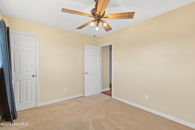 unfurnished bedroom with ceiling fan and light carpet