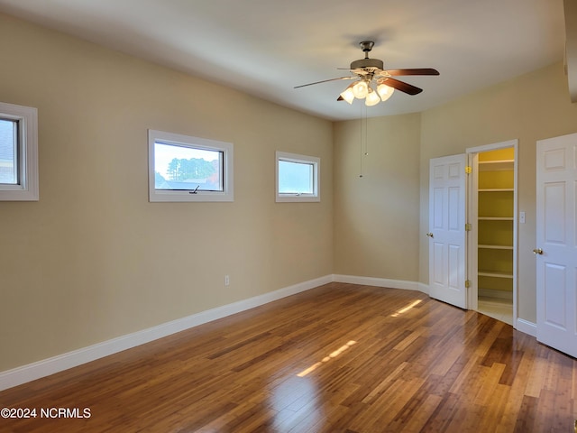 6111 Cutlass Ct, New Bern, NC 28560 - unfurnished bedroom featuring wood finished floors, baseboards, a walk in closet, and a ceiling fan