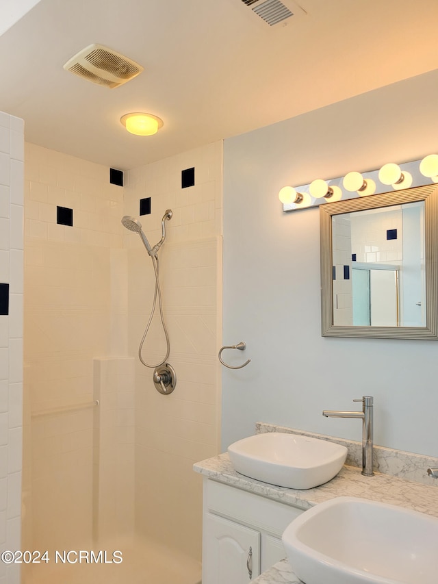 bathroom with vanity and tiled shower