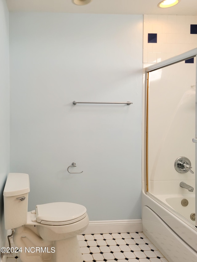 bathroom with toilet and combined bath / shower with glass door