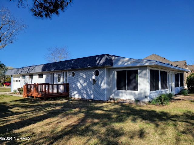 rear view of property with a lawn and a deck