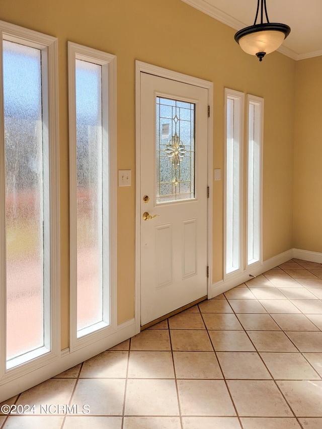 doorway featuring light tile patterned floors, a wealth of natural light, and crown molding